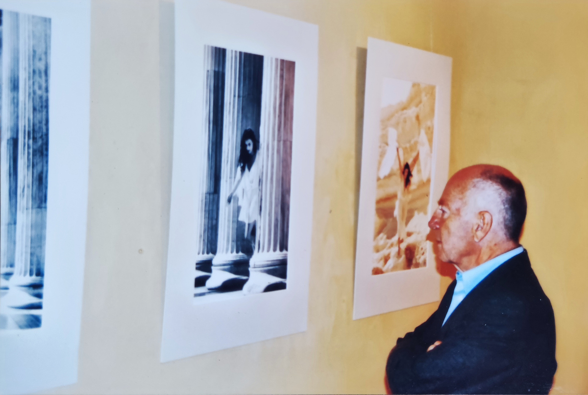 Georg Albrecht standing before photographic works by Maria Alexea