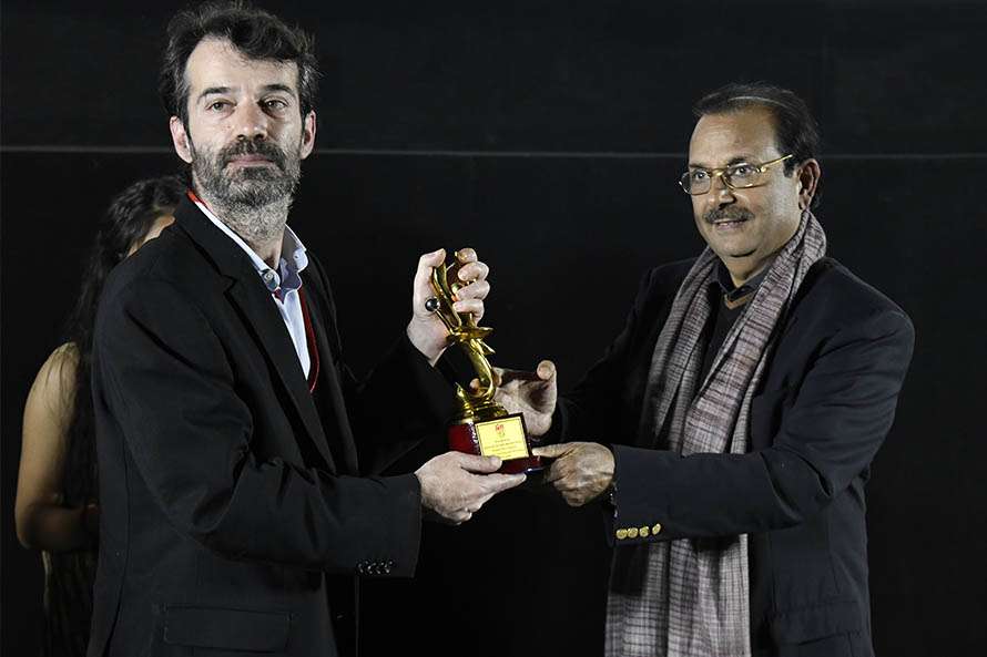 Actor portraying Faust receiving the Yellow Rose Award trophy at the Jaipur International Film Festival in 2020